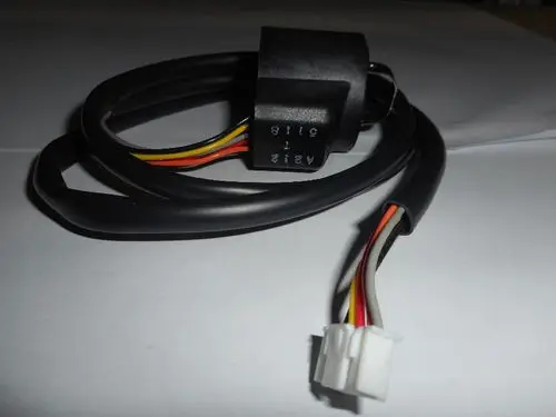 Remeha Lineardruckentspanner mit einem Kabel und mehreren farbigen Leitungen, einem schwarzen Stecker und einem weißen Verbindungselement.